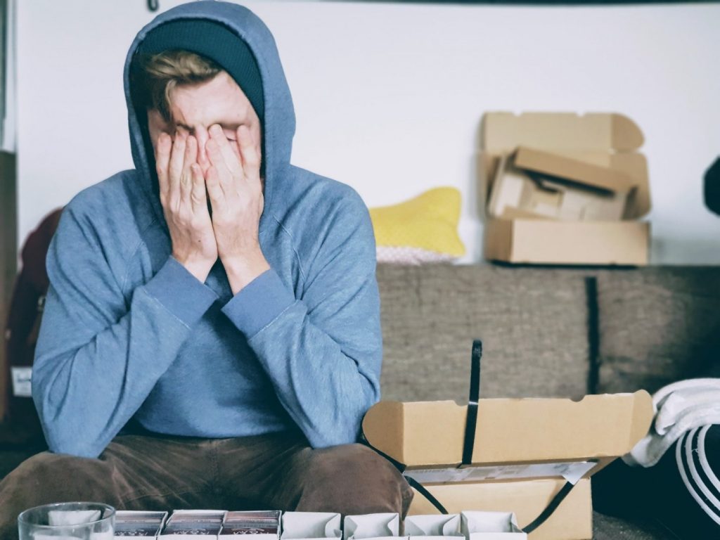 a person sitting on the couch with his hands on his face